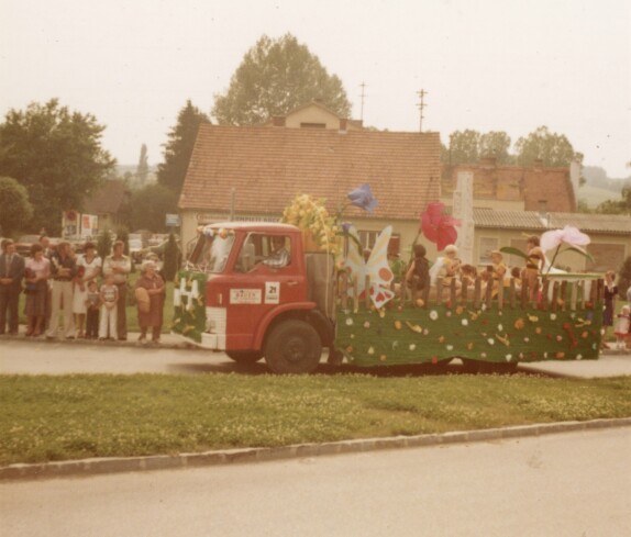 Volksfest mit Blumenkorso an der Kreuzung Grazer Straße - Kirchengasse mit dem Geschäft Elektro Vajc und dem LKW des Baustoffhandel Bauer