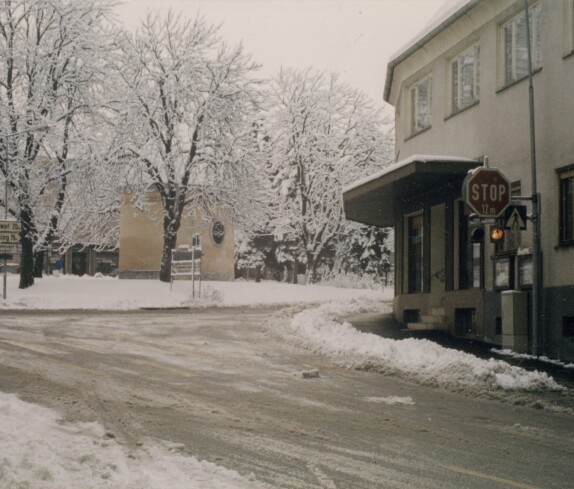 Hauptplatz, Hauptstraße und Park mit Popshop und Raika im Winter 1985/86