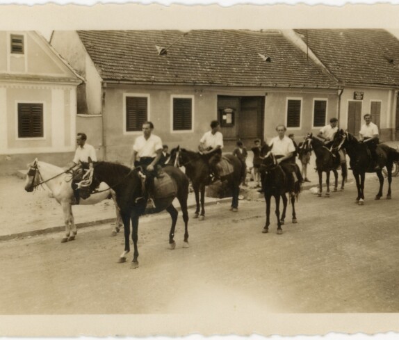 Eine Prozession in der Hauptstraße mit dem Häusern von den Familien Rothen, Six und Novakovits
